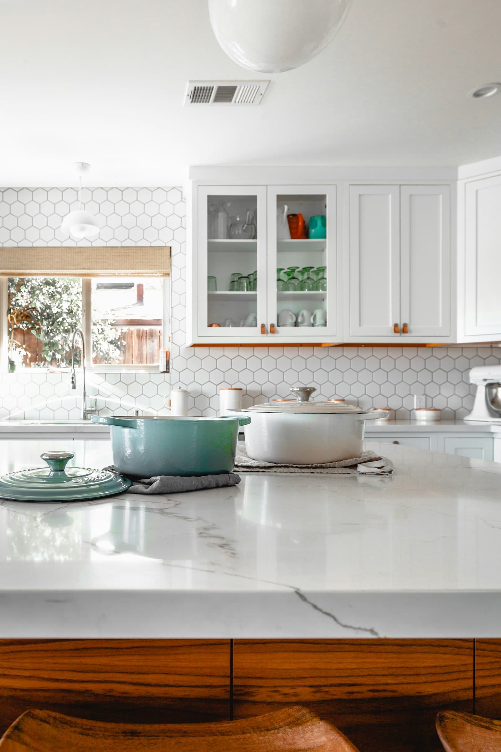 Bright kitchen island with two cooking pots on a white countertop