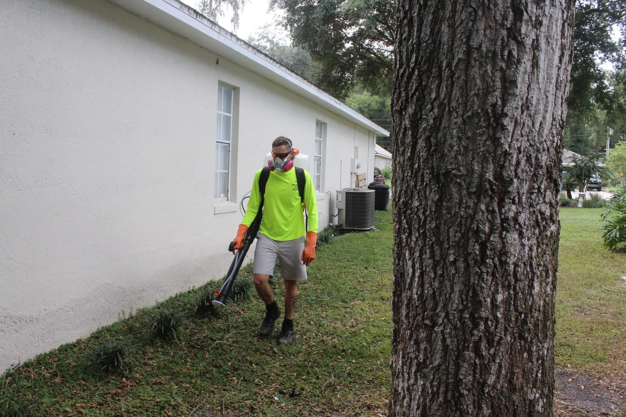 Orlando Pest Experts technician applying mosquito treatment outdoors